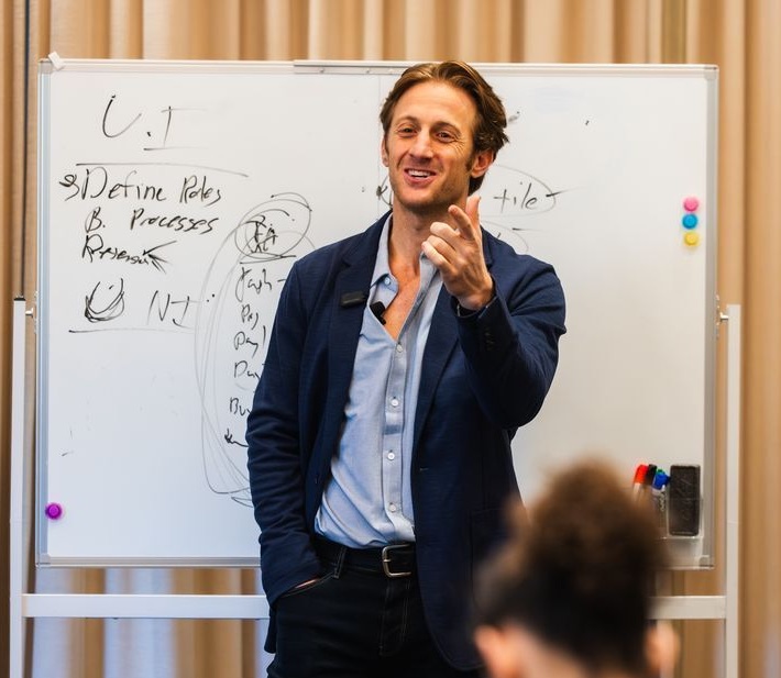 Dr. Austin Cohen teaching at a whiteboard