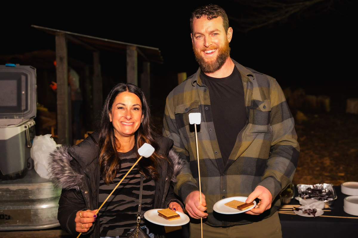 Two attendees at a nighttime s'mores social
